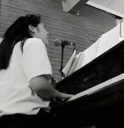 Anhthu at the piano, singing